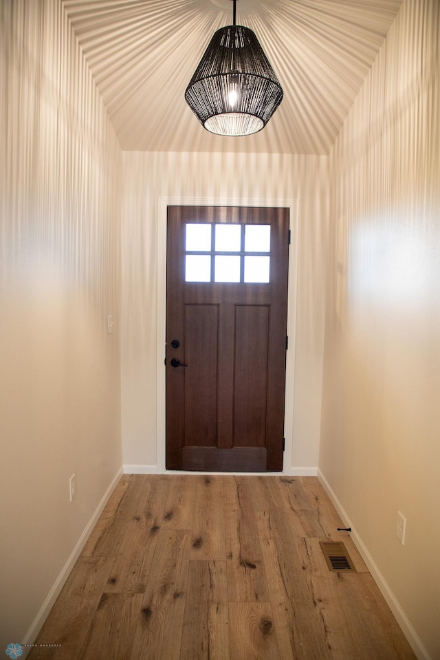 entryway featuring hardwood / wood-style flooring and vaulted ceiling