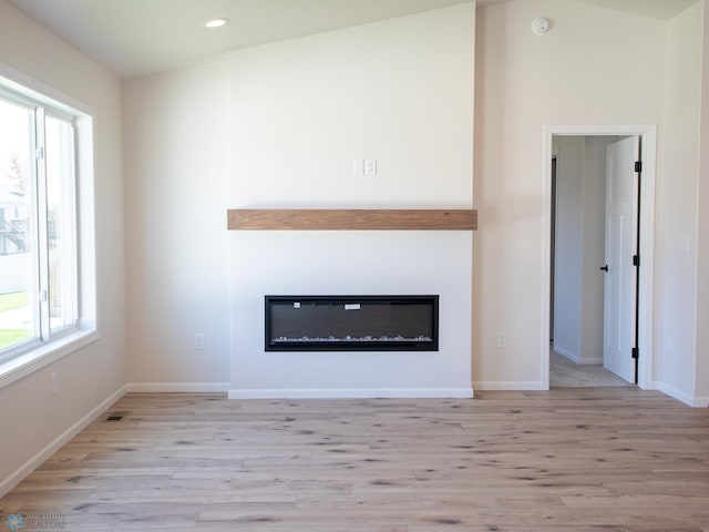 interior space featuring light wood-type flooring and lofted ceiling