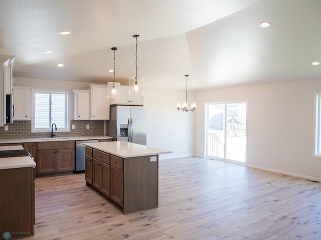 kitchen with stainless steel appliances, a wealth of natural light, light hardwood / wood-style floors, and sink