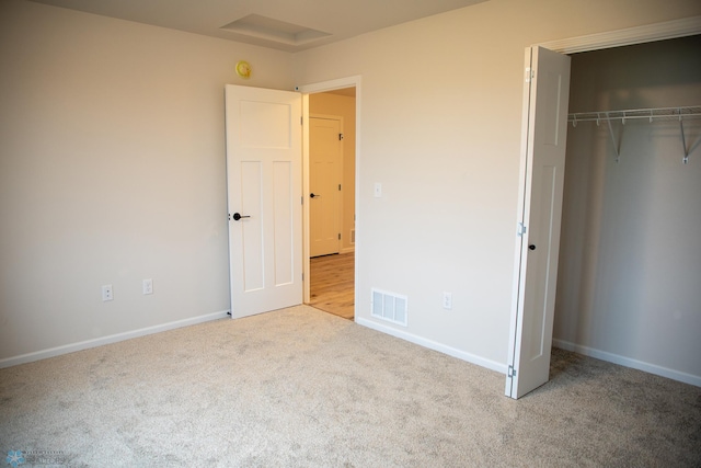 unfurnished bedroom with light carpet and a closet