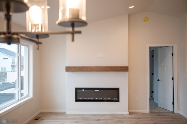 unfurnished living room with light hardwood / wood-style flooring and lofted ceiling