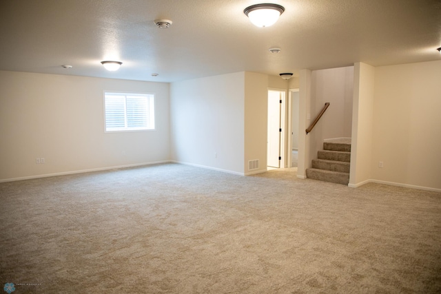 carpeted empty room with a textured ceiling