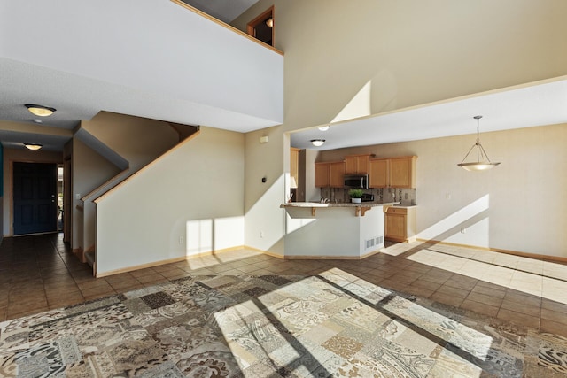 unfurnished living room with dark tile patterned flooring and a towering ceiling