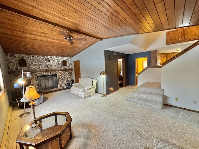 carpeted living room with vaulted ceiling with beams, ceiling fan, wood ceiling, and a fireplace