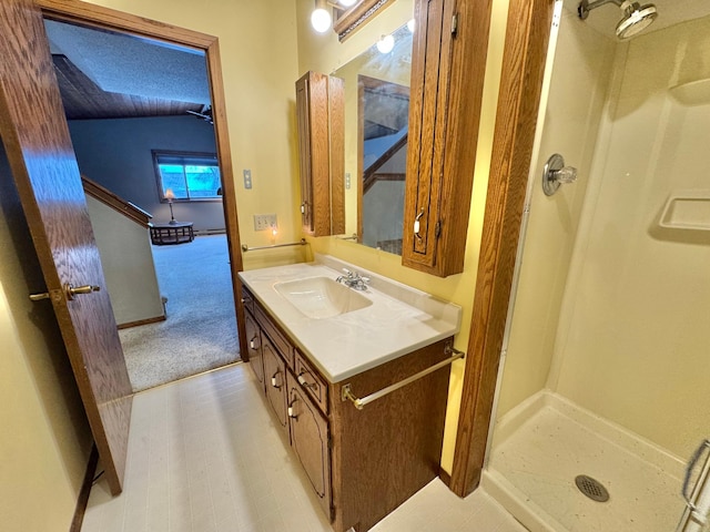 bathroom featuring vanity, a shower, and vaulted ceiling