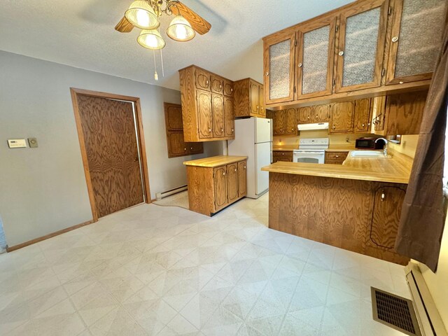 kitchen with white appliances, sink, ceiling fan, baseboard heating, and kitchen peninsula