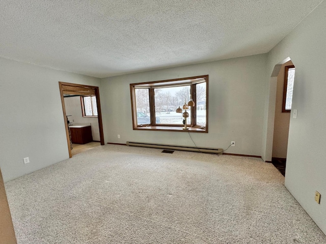 carpeted empty room with a baseboard radiator and a textured ceiling