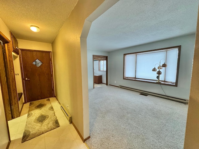 interior space featuring light colored carpet, a textured ceiling, and a baseboard radiator