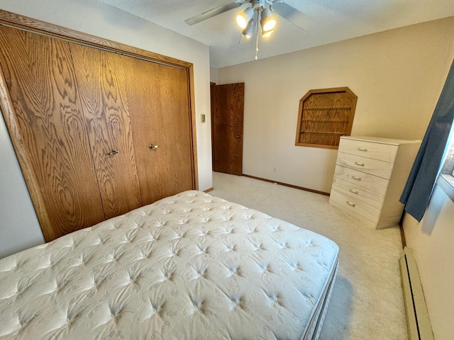 bedroom with ceiling fan, a closet, light carpet, and a textured ceiling