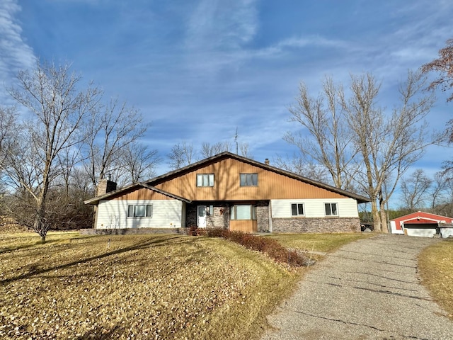 view of front facade with a garage, an outbuilding, and a front yard