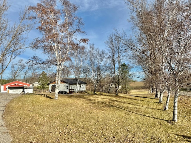 view of yard with an outbuilding, a rural view, and a garage