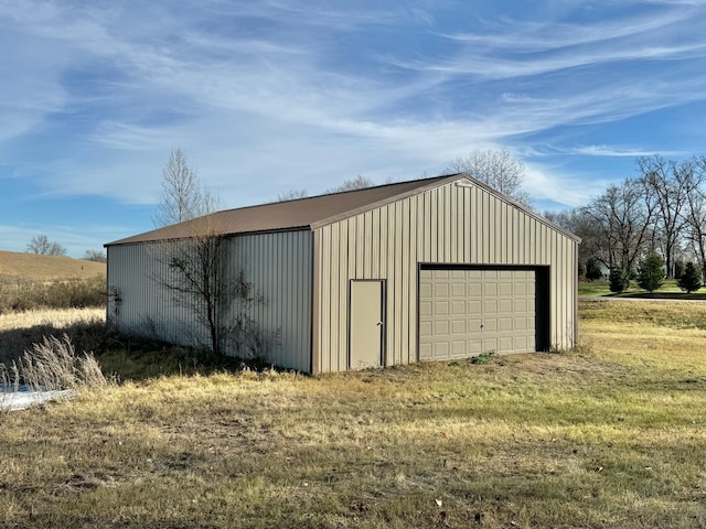 view of outbuilding with a garage and a lawn