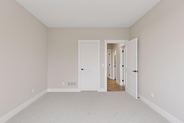 empty room featuring baseboards, visible vents, and carpet flooring