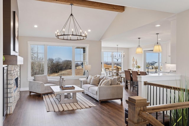 living area with dark wood-style flooring, a fireplace, recessed lighting, lofted ceiling with beams, and a chandelier