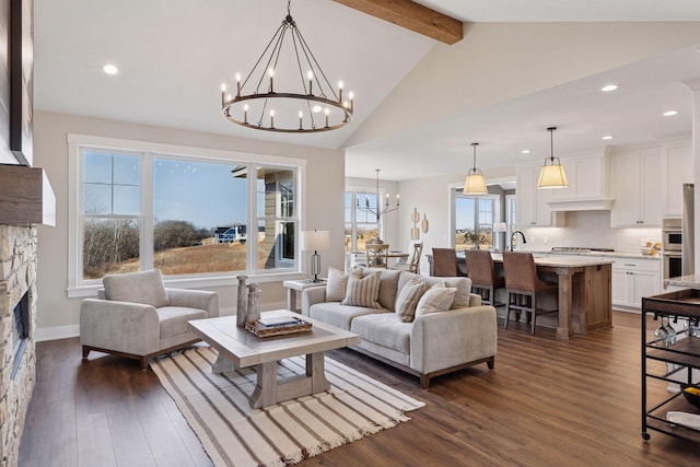 living area featuring dark wood-type flooring, vaulted ceiling with beams, a fireplace, a notable chandelier, and recessed lighting