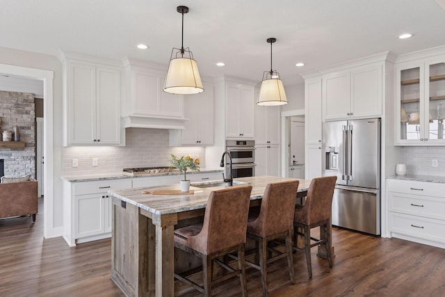 kitchen featuring appliances with stainless steel finishes, dark wood-type flooring, a sink, and white cabinetry