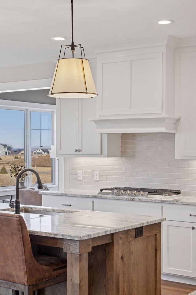 kitchen with a sink, white cabinets, and stainless steel gas stovetop