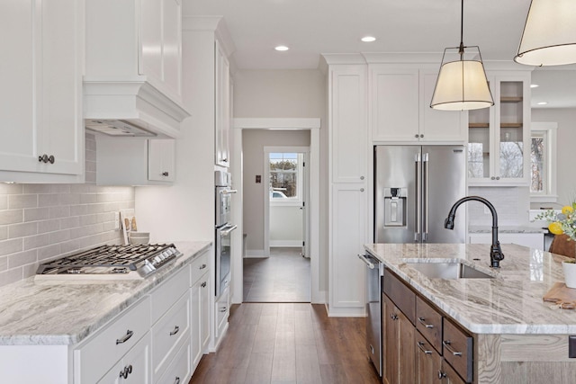 kitchen featuring stainless steel appliances, glass insert cabinets, a sink, and white cabinetry