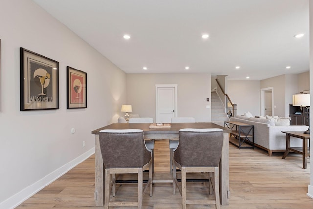 dining room with stairway, light wood-style flooring, baseboards, and recessed lighting