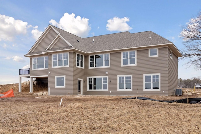 rear view of property featuring a shingled roof and central air condition unit