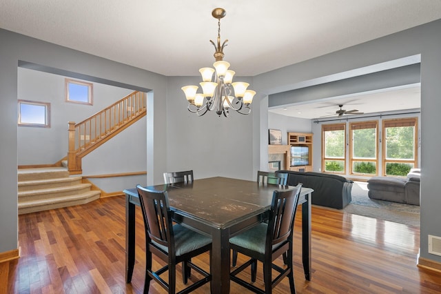 dining room featuring hardwood / wood-style floors and ceiling fan with notable chandelier