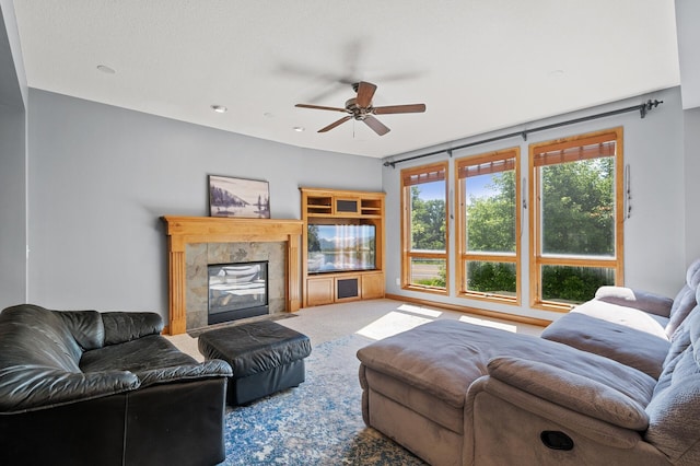 carpeted living room with ceiling fan, a high end fireplace, and a textured ceiling