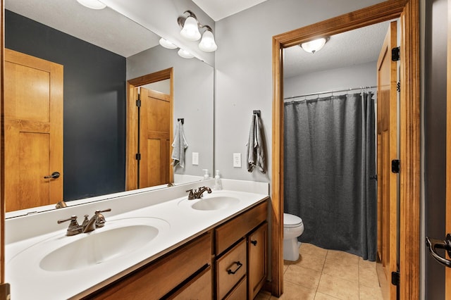 bathroom with tile patterned flooring, vanity, a textured ceiling, and toilet