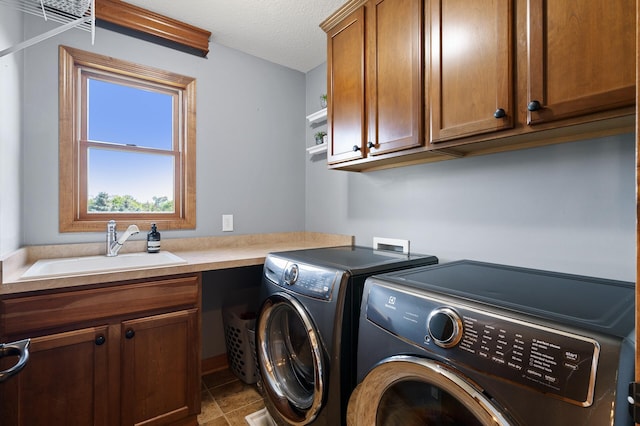 clothes washing area featuring cabinets, sink, tile patterned flooring, independent washer and dryer, and a textured ceiling