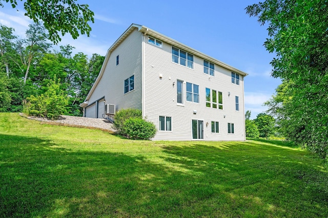 back of house with a garage and a lawn