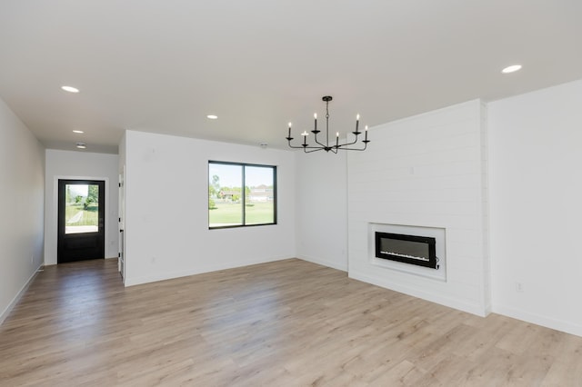 102 3rd Ave, Pelican Rapids, MN 56572 - unfurnished living room featuring a chandelier, recessed lighting, light wood-style floors, and a large fireplace