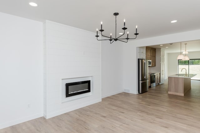 102 3rd Ave, Pelican Rapids, MN 56572 - unfurnished living room featuring a chandelier, light wood-style floors, recessed lighting, and a fireplace
