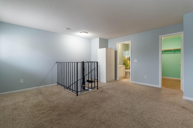 carpeted empty room featuring a textured ceiling