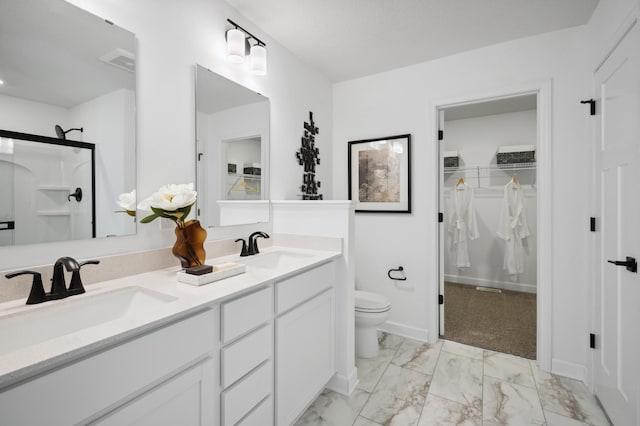 bathroom featuring vanity, toilet, and a shower with door