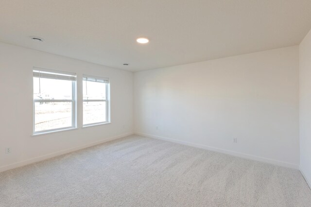 spare room featuring light colored carpet