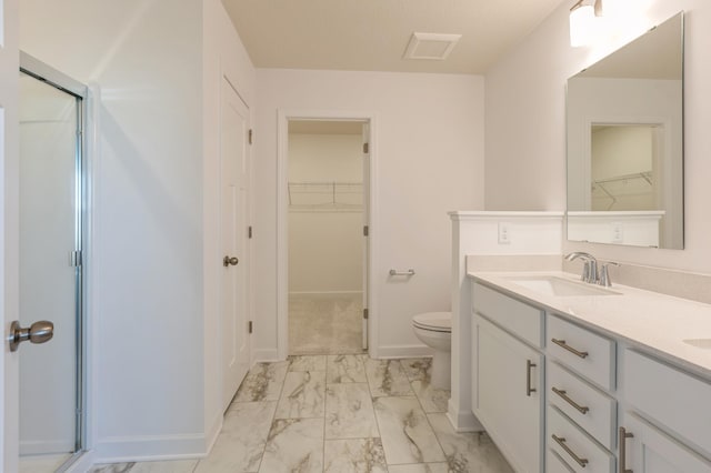 bathroom with vanity, a shower with shower door, and toilet