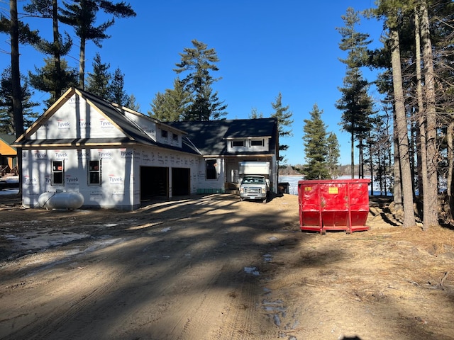 view of property exterior featuring an attached garage and dirt driveway