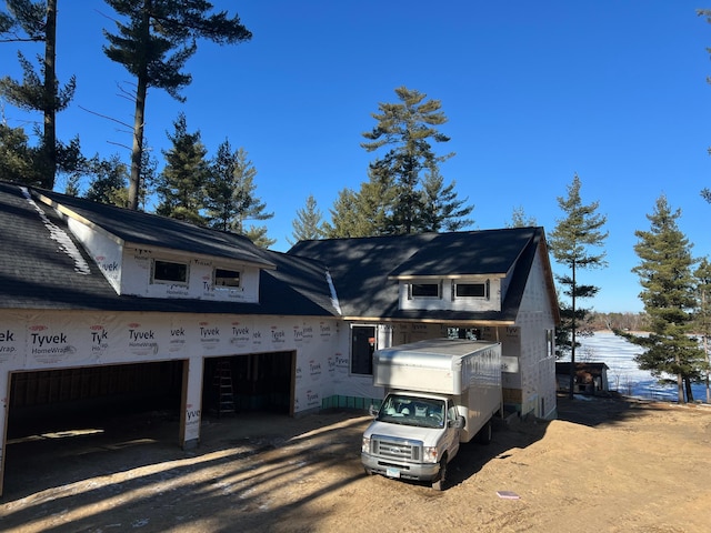 view of side of home with a garage and dirt driveway