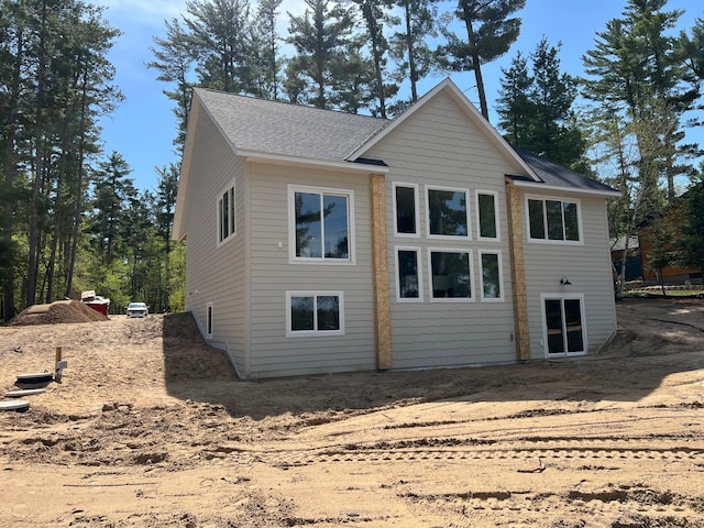 back of property with roof with shingles