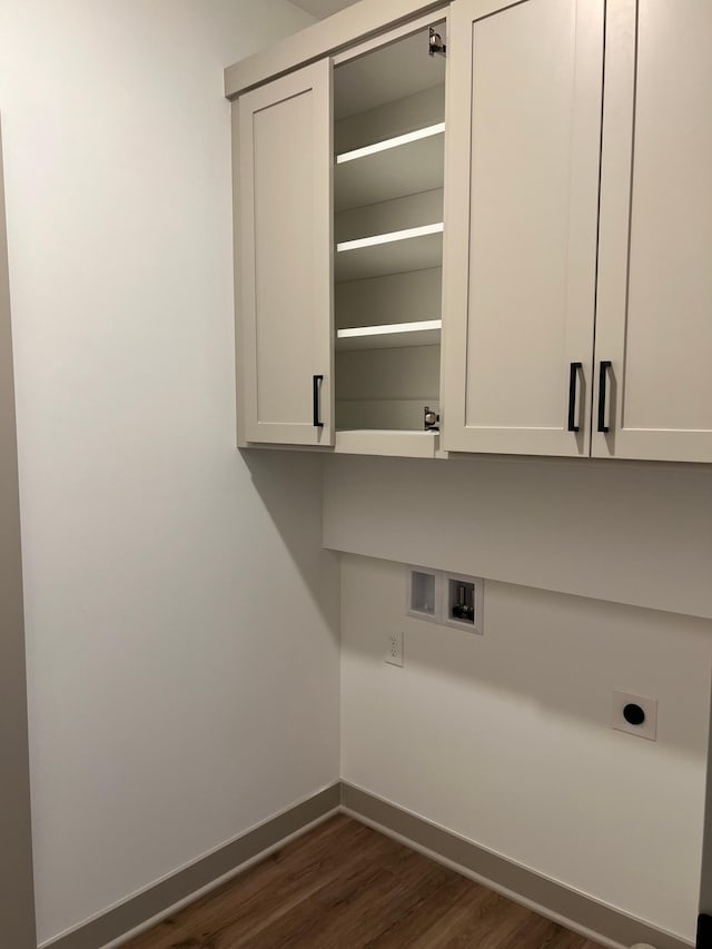laundry room with cabinet space, electric dryer hookup, dark wood-style floors, baseboards, and hookup for a washing machine