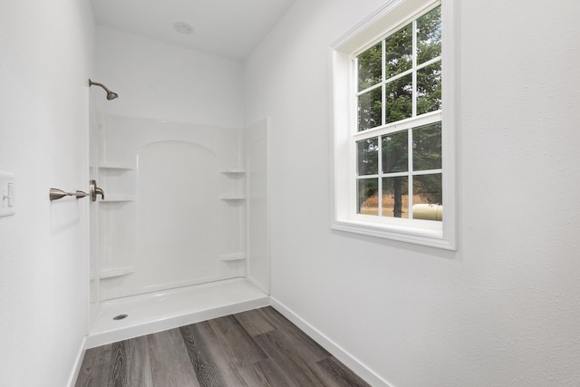 bathroom with hardwood / wood-style flooring and walk in shower