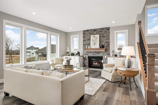 living room featuring a fireplace, wood-type flooring, and a wealth of natural light