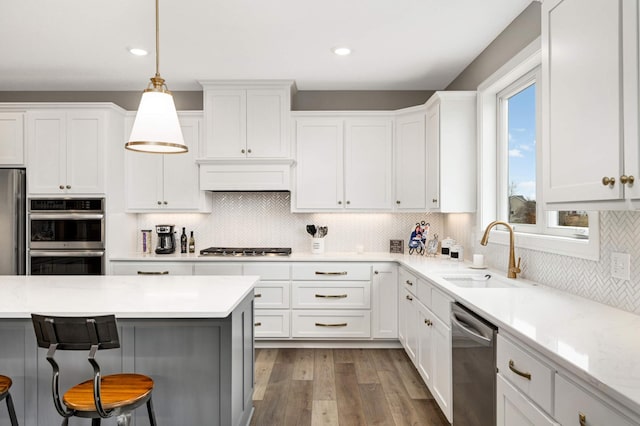 kitchen featuring sink, stainless steel appliances, tasteful backsplash, dark hardwood / wood-style flooring, and decorative light fixtures