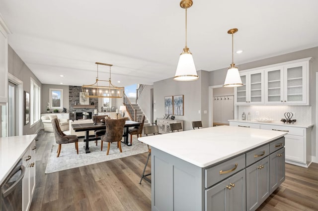 kitchen with a center island, gray cabinets, hanging light fixtures, and dark wood-type flooring