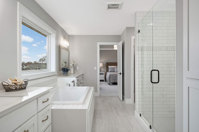 bathroom with vanity and independent shower and bath