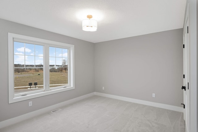 carpeted spare room with a textured ceiling