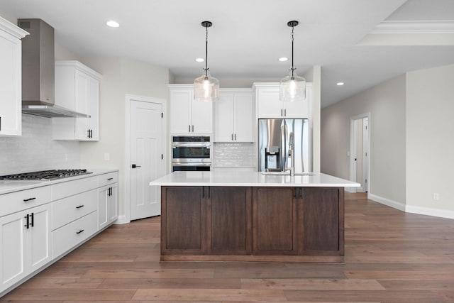 kitchen featuring a center island, dark hardwood / wood-style floors, wall chimney range hood, and appliances with stainless steel finishes