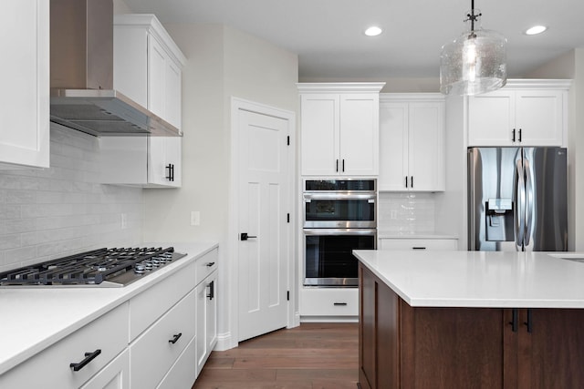 kitchen with white cabinets, dark wood-type flooring, wall chimney exhaust hood, and stainless steel appliances