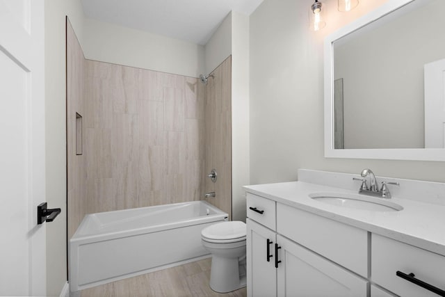 full bathroom with hardwood / wood-style flooring, vanity, toilet, and tiled shower / bath