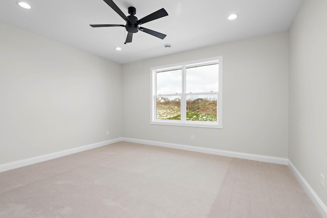 carpeted spare room featuring ceiling fan