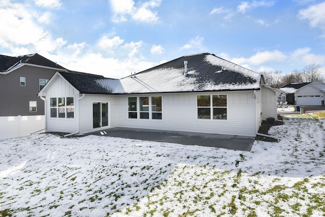 view of snow covered rear of property